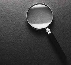 Magnifying glass on black texture background